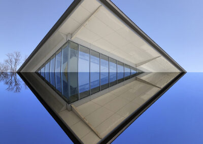 Photo composition of modernist architecture reflected on a blue background