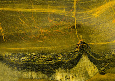 A black and yellow volcano-like mineral pattern seems to spew veins of red lava upwards