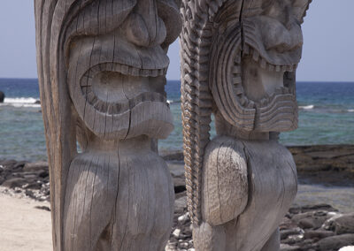 Wooden statues stand at a beach in Hawaii