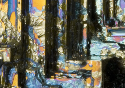 Iridescent cub crystals form a stairstep pattern on a black matrix