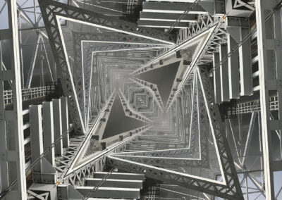 Photo composition of geometric beams and girders reflected to resemble a tower viewed from the bottom