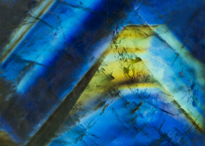 Pyramid-like crystal of blue and green on on a darker blue background