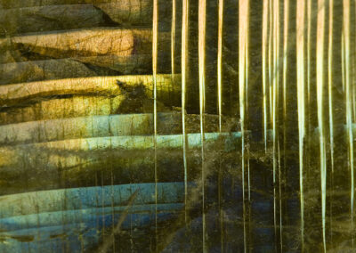 Iridescent crystals in a blue, green and yellow stairstep pattern coexist with sharp yellow vertical lines