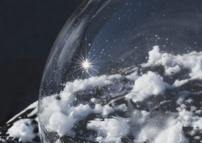 A large bubble forms a dome over smaller suds