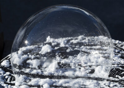 A large bubble forms a dome over smaller suds