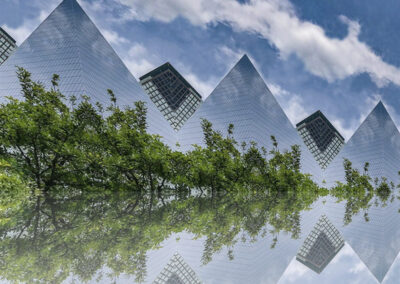 A photo composition of pyramid-like architecture and a treeline