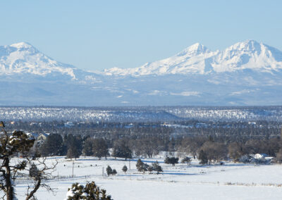 Landscape photo of three mountains overlooking a snowy Oregon valley