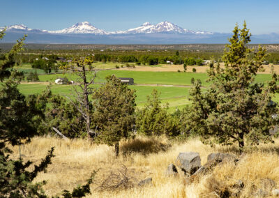 Landscape photo of three snowy mountains overlooking an Oregon valley