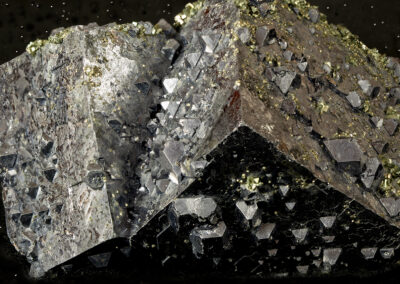 Gray crystalline form on a black background resembling an asteroid with pyramidal protrusions
