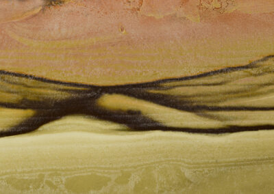 Mineral in yellow and brown resembling a desert landscape