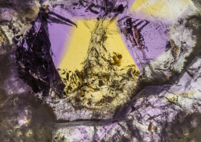 Mineral with brown brushstroke-like markings and tinted in mustard and lavender colors