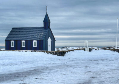 A black church in the snow at Búðir
