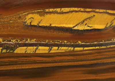 Orange and brown striations broken by bright yellow intrusions