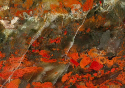 Red pools with wispy gray cracks resemble a lava scene