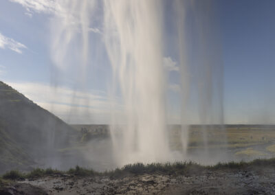 A veil of mist at the top of a waterfall in Iceland