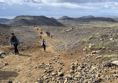 Visitors explore a field of volcanic rock at Reykjanes in Iceland