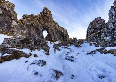 Rocky outcrops jut through the snow at an Iceland shore