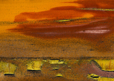 Red and yellow clouds hang over a yellow and brown granular landscape