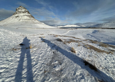 Long shadows of the photographer point toward Kirkjufell in Iceland