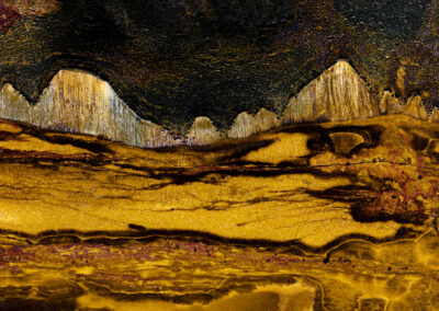 Crystal layers and striations resembling a hilly landscape in yellow and orange