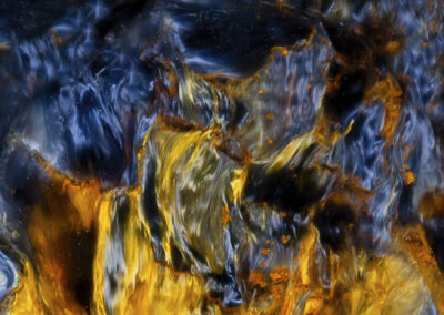 A mineral formation of swirling yellow, orange and blue flamelike patterns