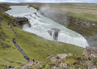 Two-step waterfall in Iceland with line of visitors