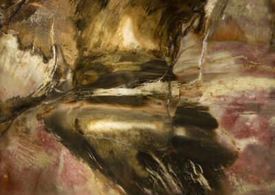 Swirling pink and black mineral patterns surround a flamelike yellow spot