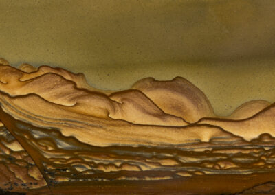 Landscape-like tan and brown hills below an olive-colored sky