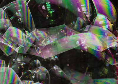 A congeries of iridescent bubbles form patterns and reflections