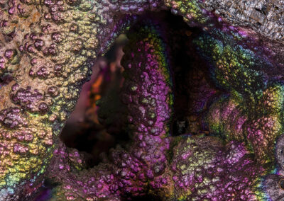 Iridescent nodules form an opening into a dark cavelike area