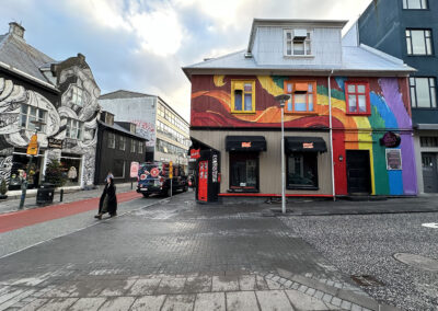 Icelandic buildings covered with murals both rainbow-colored and monochrome
