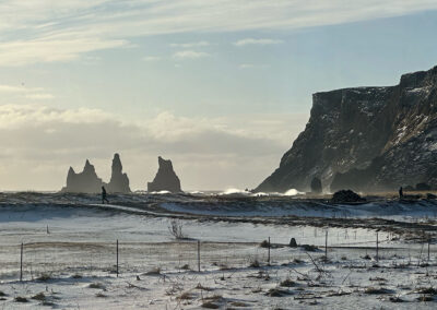Coastal scene with rocky outcrops and a single walking figure