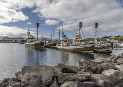 Icelandic harbor with rocky jetty and fishing boats