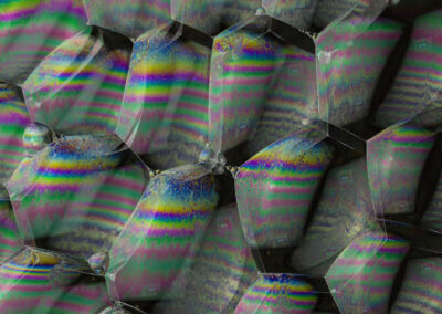 Iridescent bubbles form geometric patterns like a compound eye