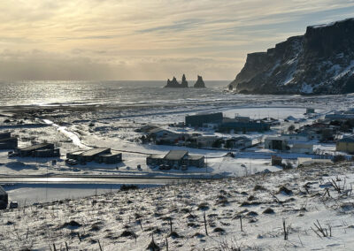Icelandic village with sea and rocky promontories in background