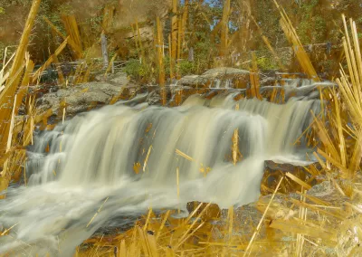 A calmly flowing waterfall amid golden crystalline structures