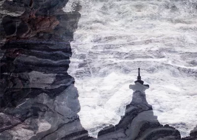 A stone temple-like structure is overlaid by whitecaps